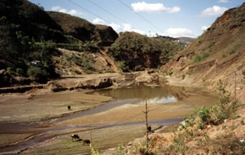 Figuras 3 – Eroso nas encostas e assoreamento da calha principal do ribeiro do Carmo. 