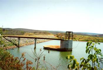 (b) Barragem em enchimento com vertedor em tulipa